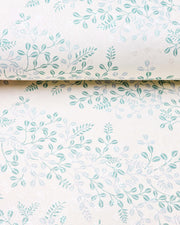 Japanese chiyogami paper featuring light blue and turquoise hagi (bush clover) on a light cream background with metallic silver details, shown rolled to highlight the design.