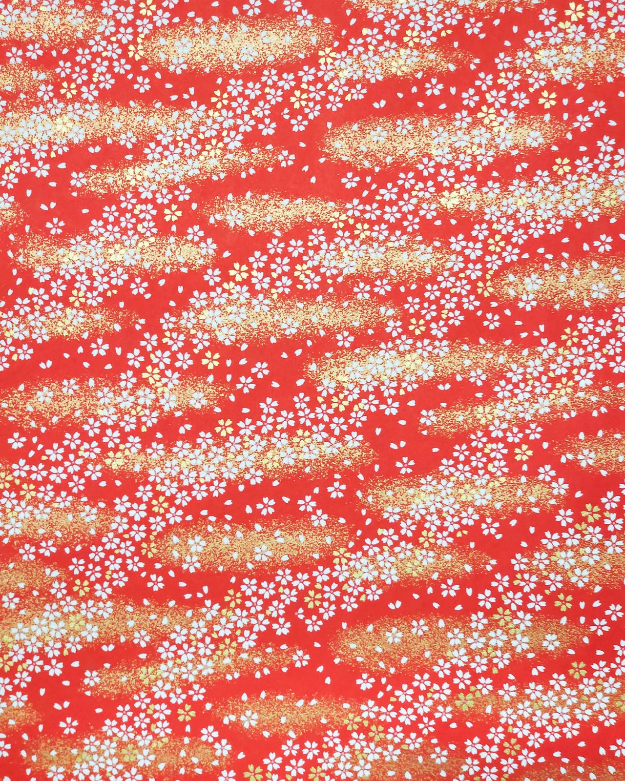 Japanese chiyogami paper featuring small white and gold cherry blossoms on a red background with metallic gold details.