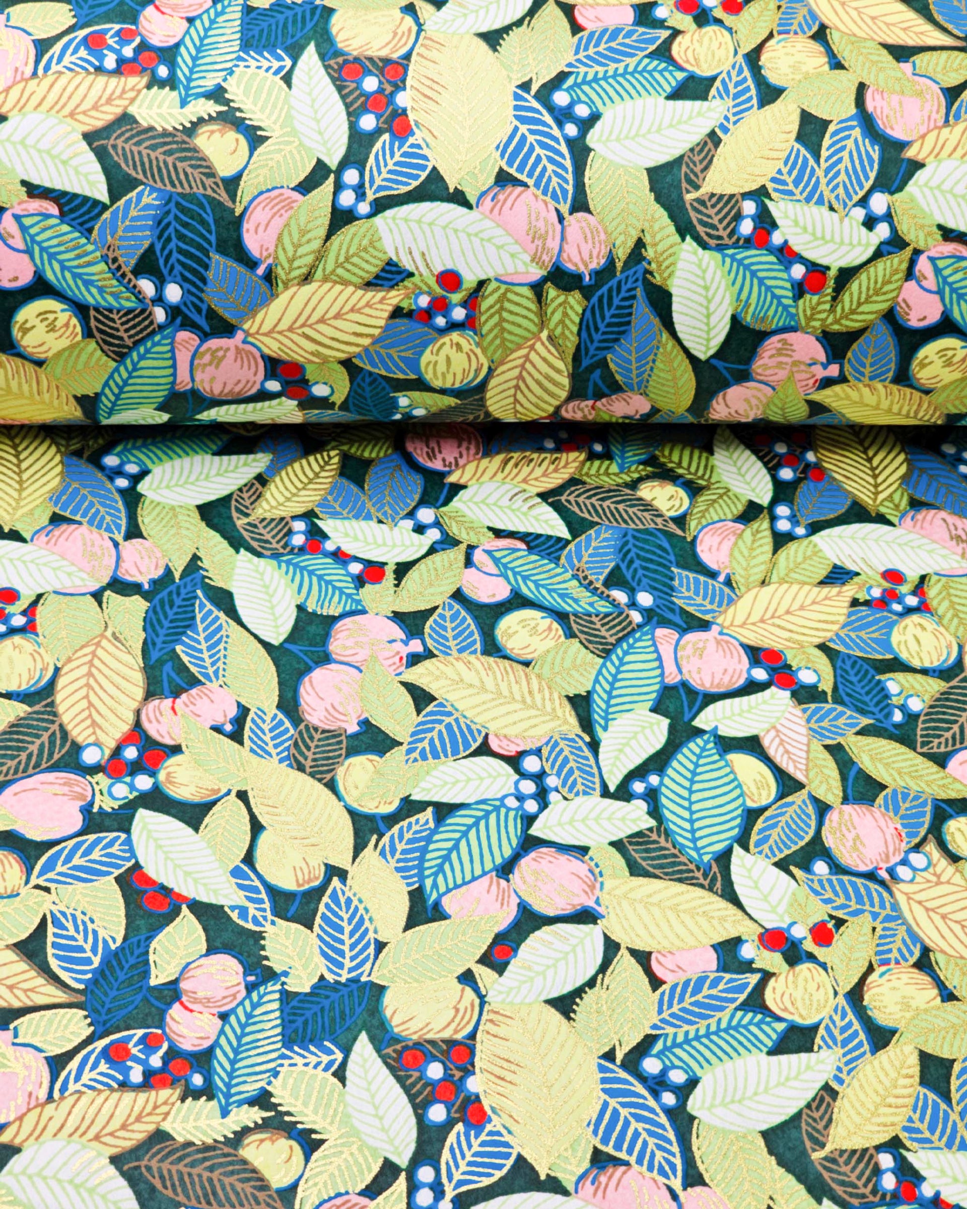 Japanese chiyogami paper featuring green, blue, and yellow leaves with pink persimmon fruits on a dark green background with metallic gold details, shown next to a ruler for size reference.