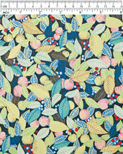 Japanese chiyogami paper featuring green, blue, and yellow leaves with pink persimmon fruits on a dark green background with metallic gold details, shown rolled to highlight the design.