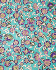 Japanese chiyogami paper featuring purple and green sarasa flowers on a pearlescent green background with metallic gold accents.