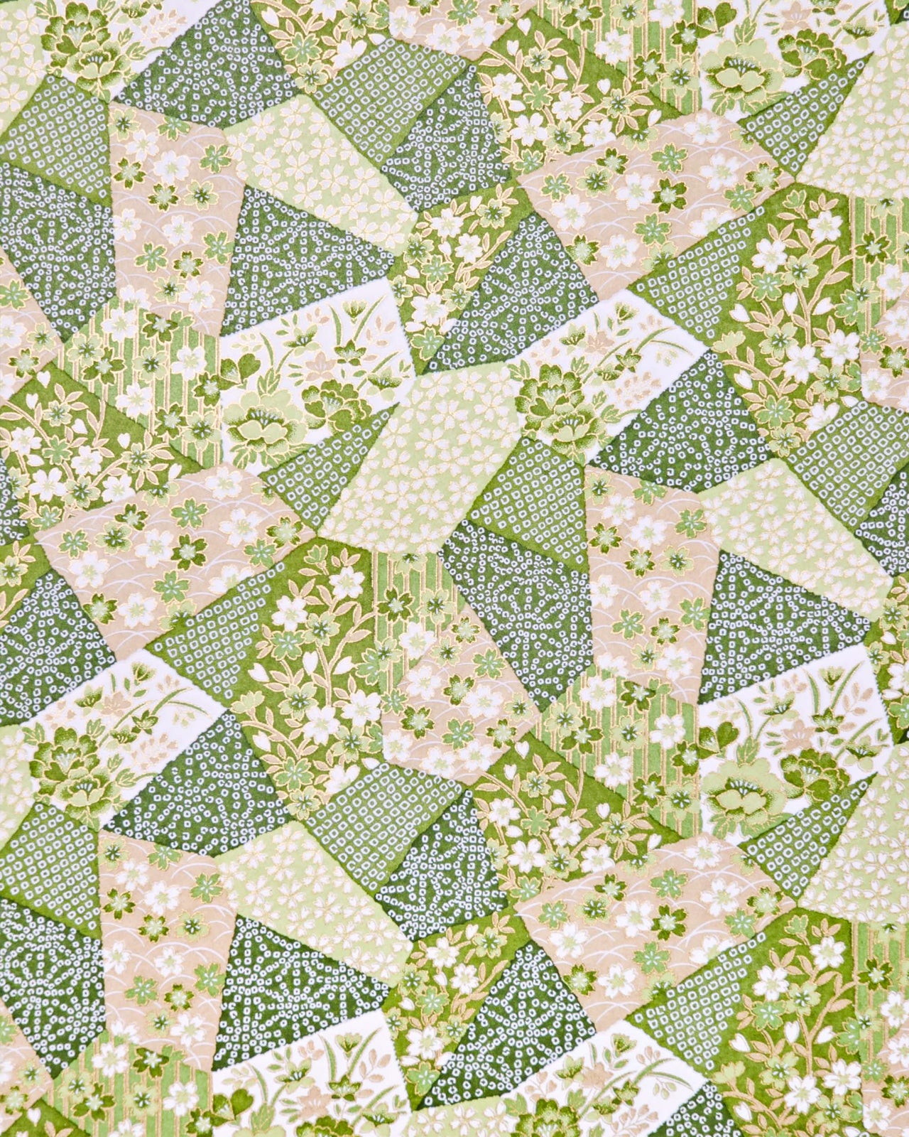 Japanese chiyogami paper featuring green, beige, and white floral patches embedded with assorted geometric and floral designs with metallic gold details.