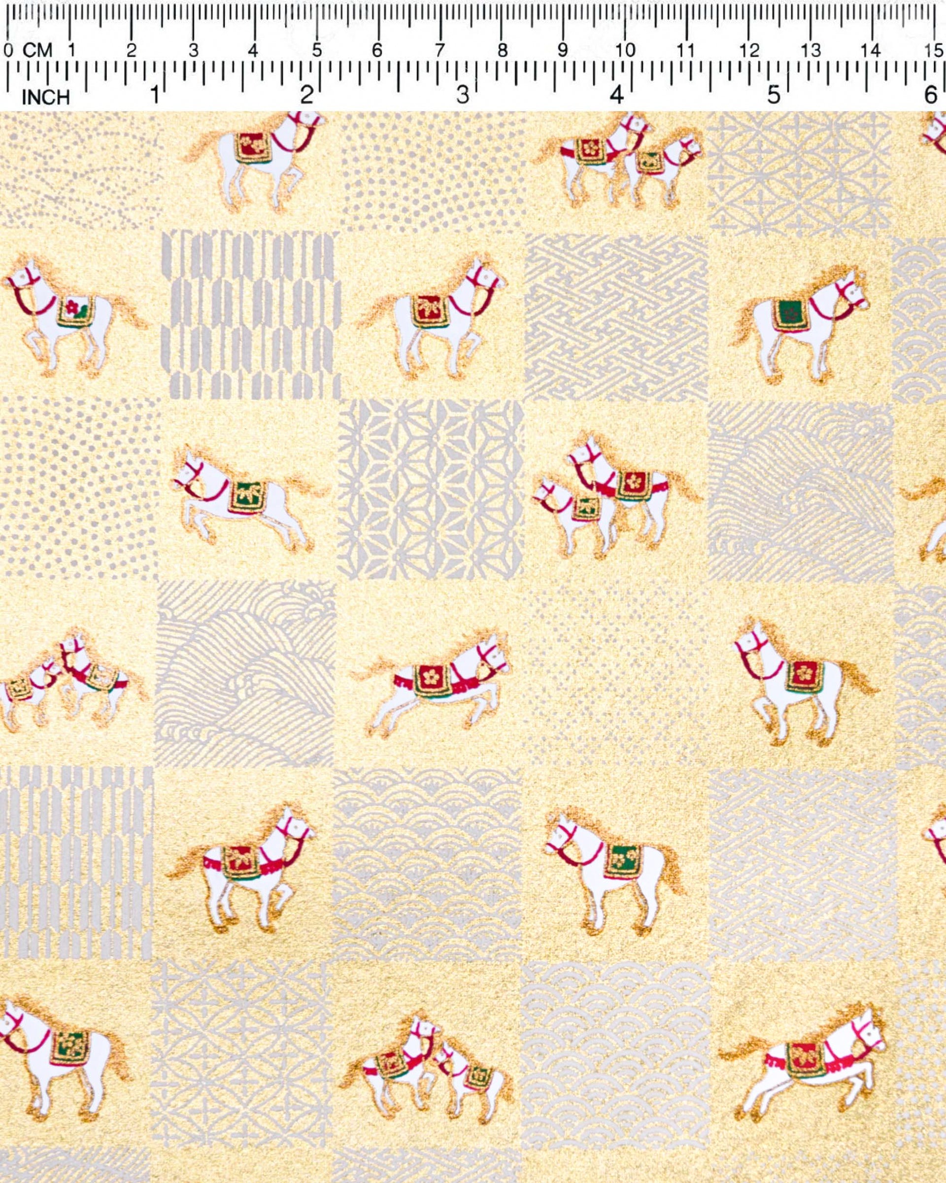 Japanese chiyogami paper featuring white horses with red and green accents and white assorted traditional Japanese designs in an ichimatsu (checker) design on a metallic gold background.
