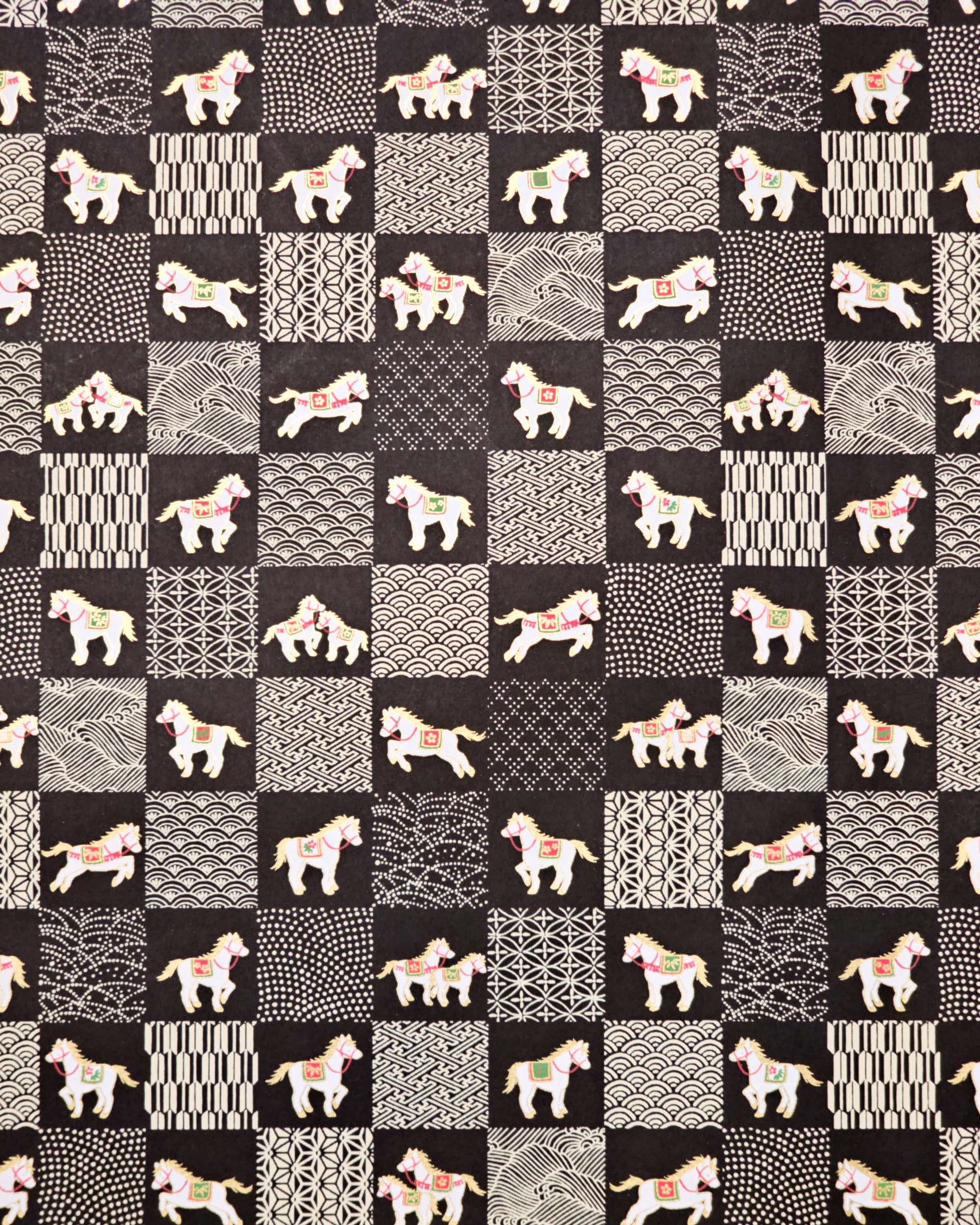 Japanese chiyogami paper featuring white horses with gold manes wearing red and green saddles and bridles, alternating with assorted off-white traditional Japanese patterns in an ichimatsu (checker) design on a black background.