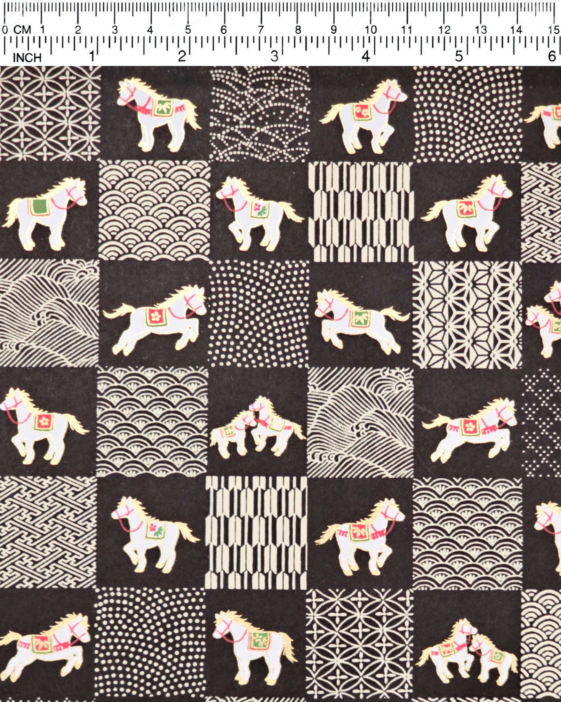 Japanese chiyogami paper featuring white horses with red and green accents and beige assorted traditional Japanese designs in an ichimatsu (checker) design on a black background with metallic gold accents.
