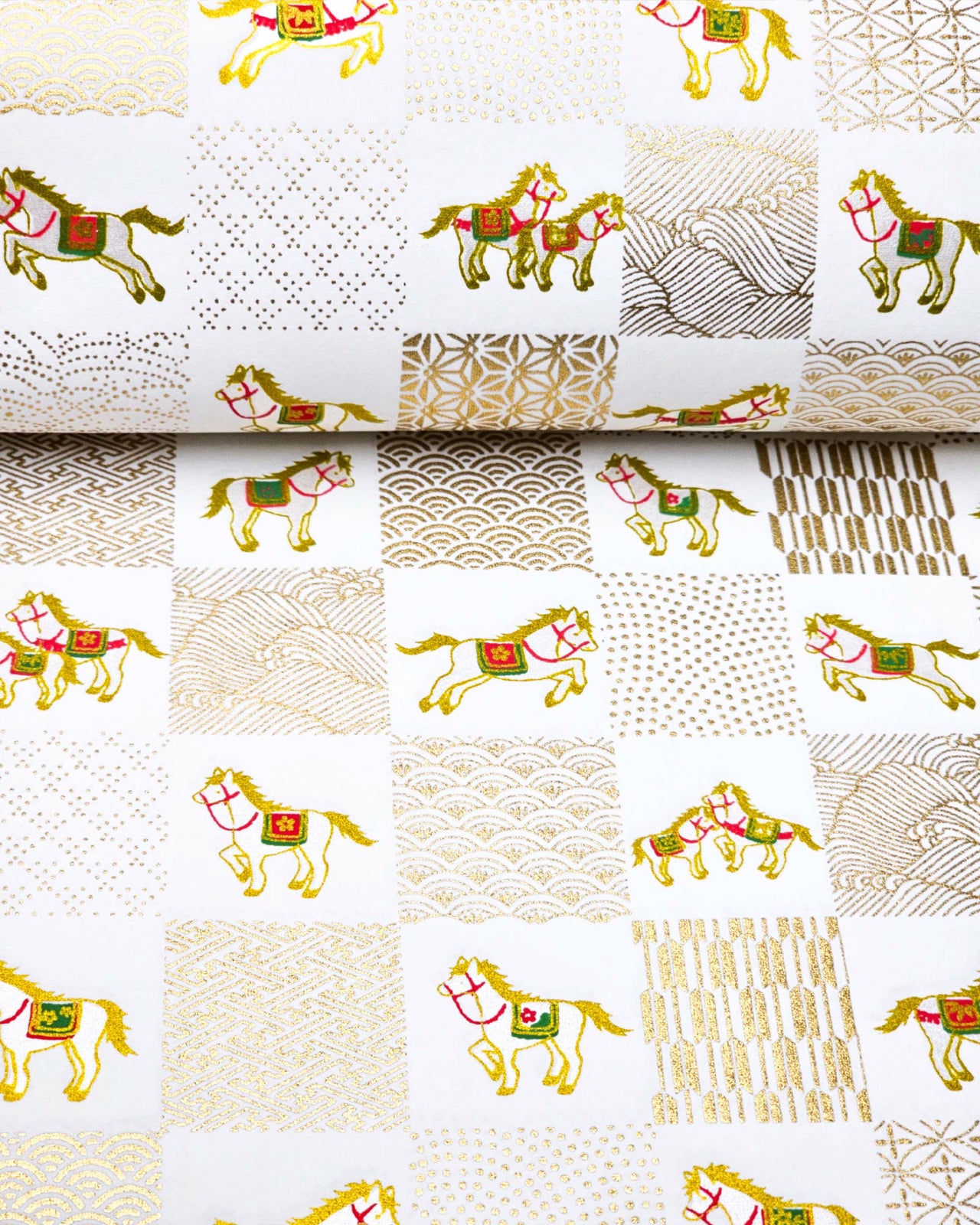 Japanese chiyogami paper featuring silver horses with red and green accents and gold assorted traditional Japanese designs in an ichimatsu (checker) design on a white background with metallic gold accents.