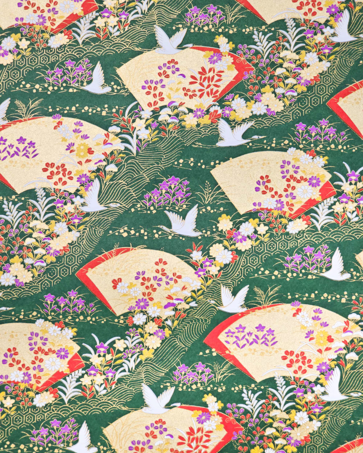 Japanese chiyogami paper featuring white flying cranes, gold and red folding fans, and assorted red, purple, white, and yellow flowers on a green background with metallic gold wave and geometric details.