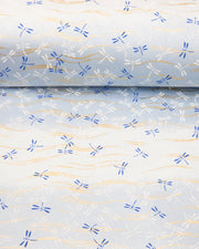 Japanese chiyogami paper featuring blue and white dragonflies on a pearlescent light blue gradient background with metallic gold wavy lines, shown rolled to highlight the design.