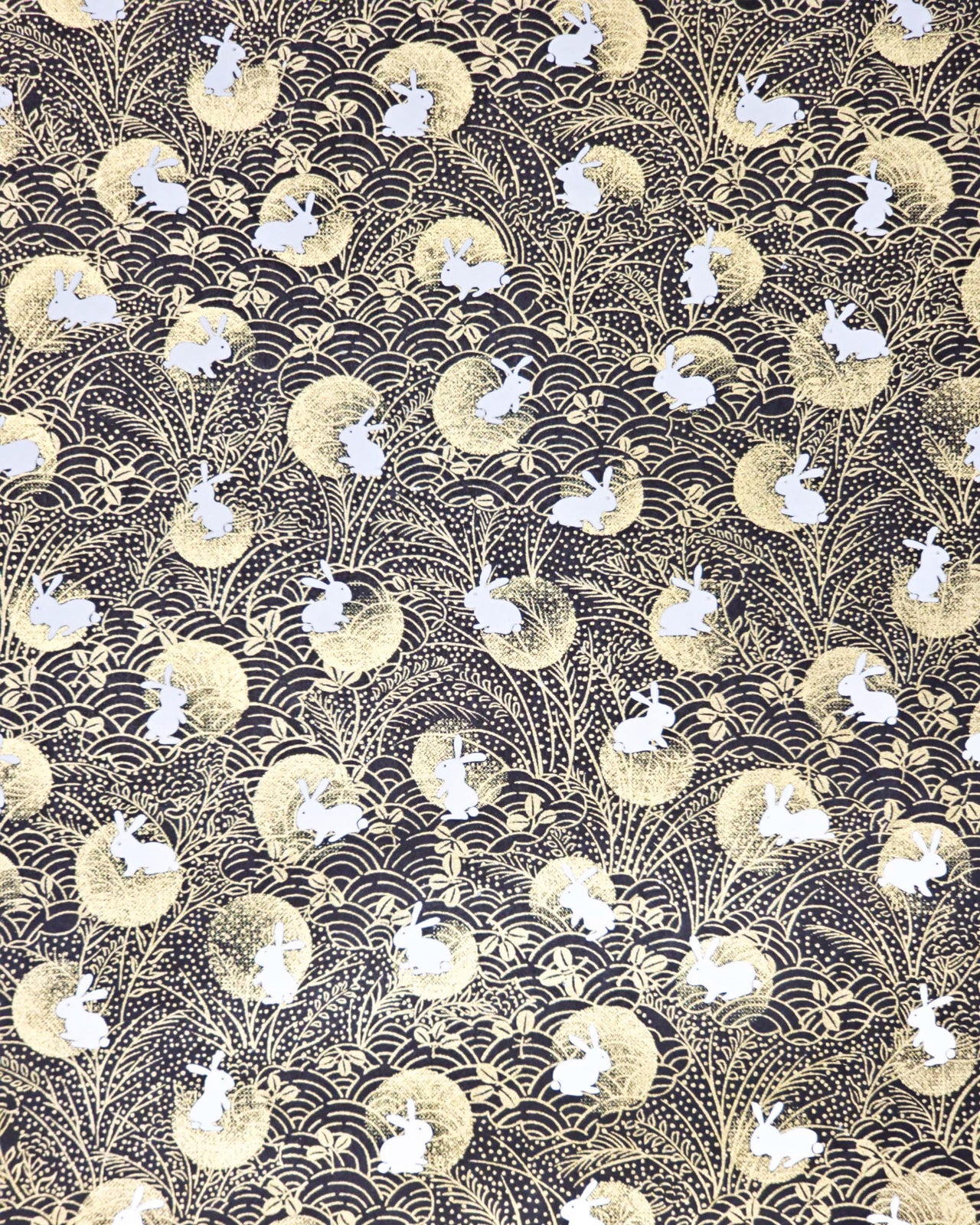 Japanese chiyogami paper featuring white rabbits with gold moons on a black background with metallic gold accents.