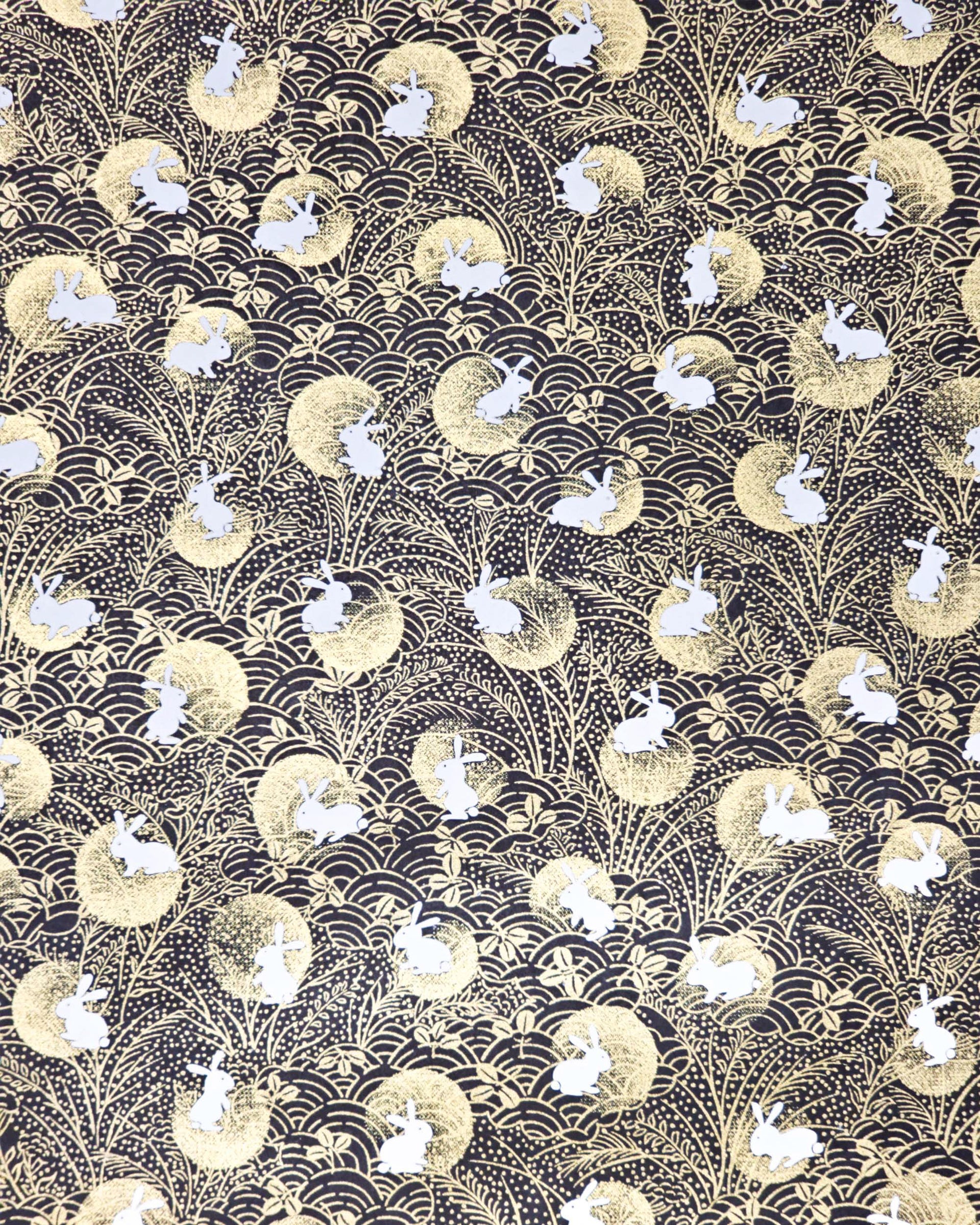 Japanese chiyogami paper featuring white rabbits with gold moons on a black background with metallic gold accents.