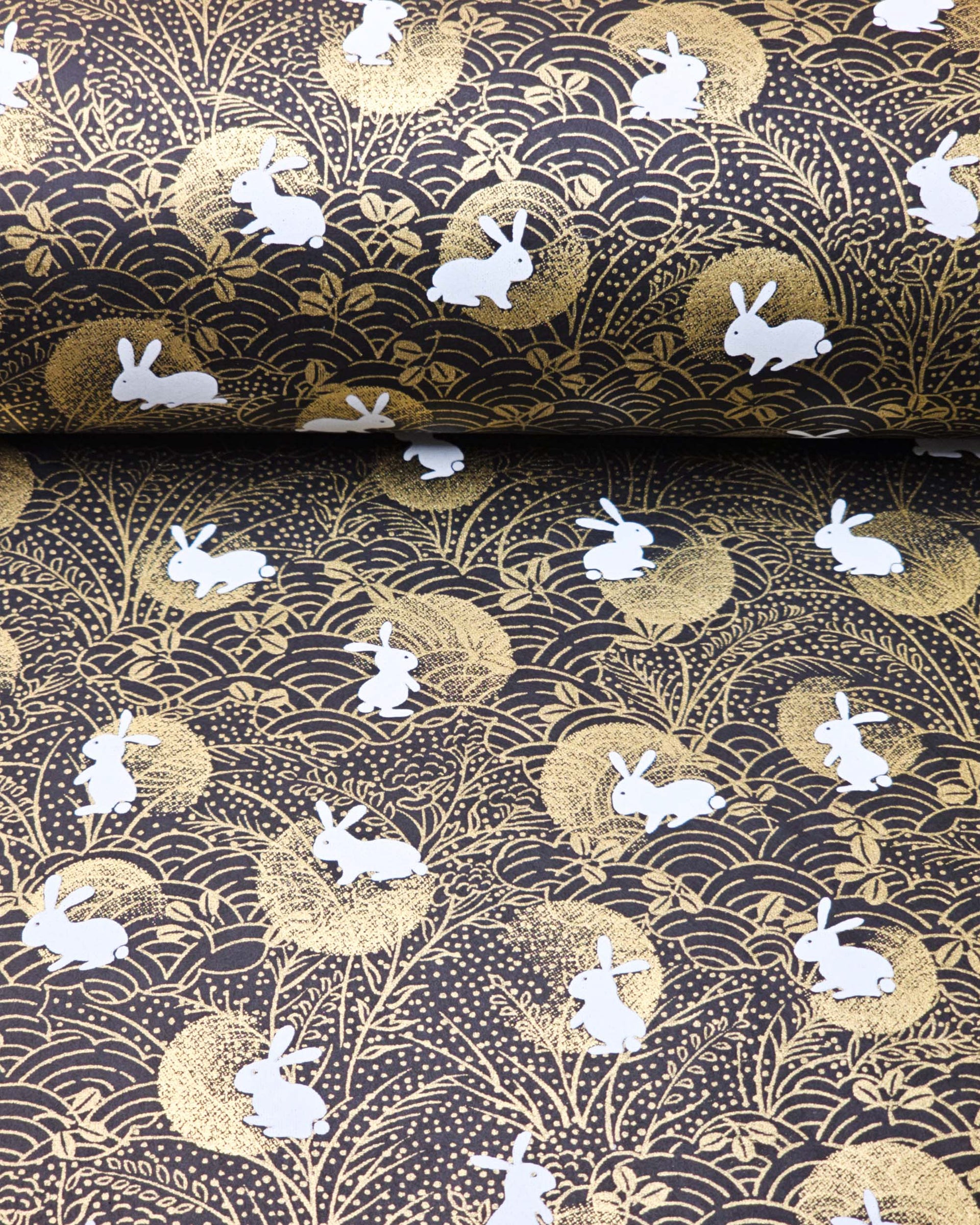 Japanese chiyogami paper featuring white rabbits with gold moons on a black background with metallic gold accents.