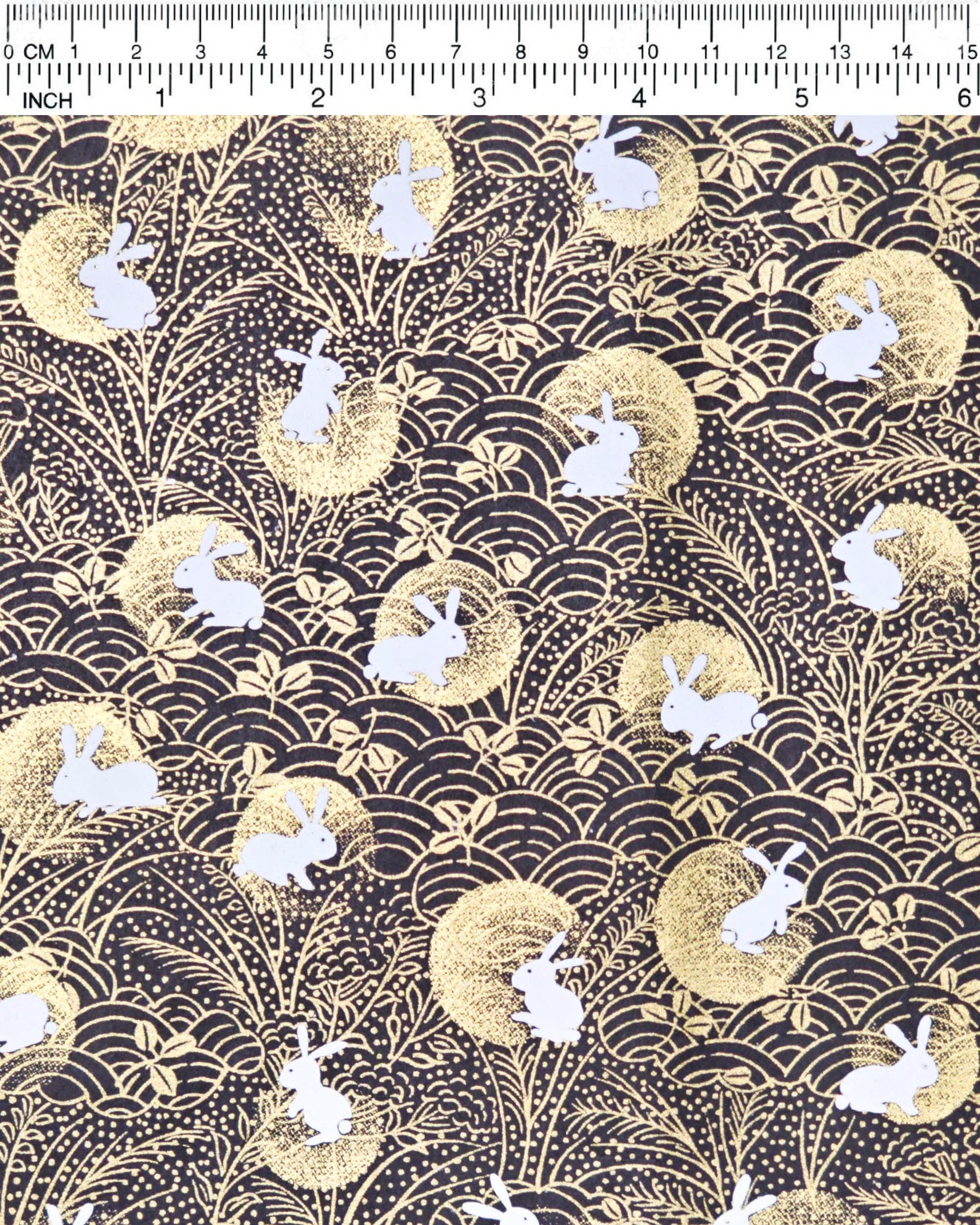 Japanese chiyogami paper featuring white rabbits with gold moons on a black background with metallic gold accents.