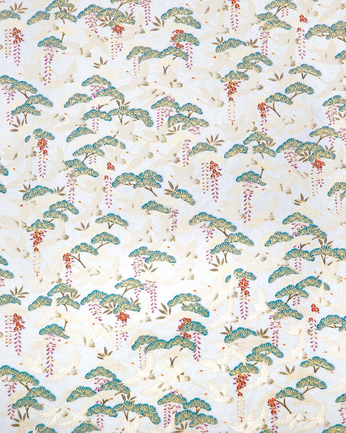 Japanese chiyogami paper featuring white flying cranes, purple and red wisteria, and green pine on a pearlescent light blue background with metallic gold details.
