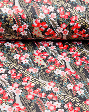 Japanese chiyogami paper featuring red and white plum blossoms with red, white, and green wisteria on a black back ground with metallic gold accents.