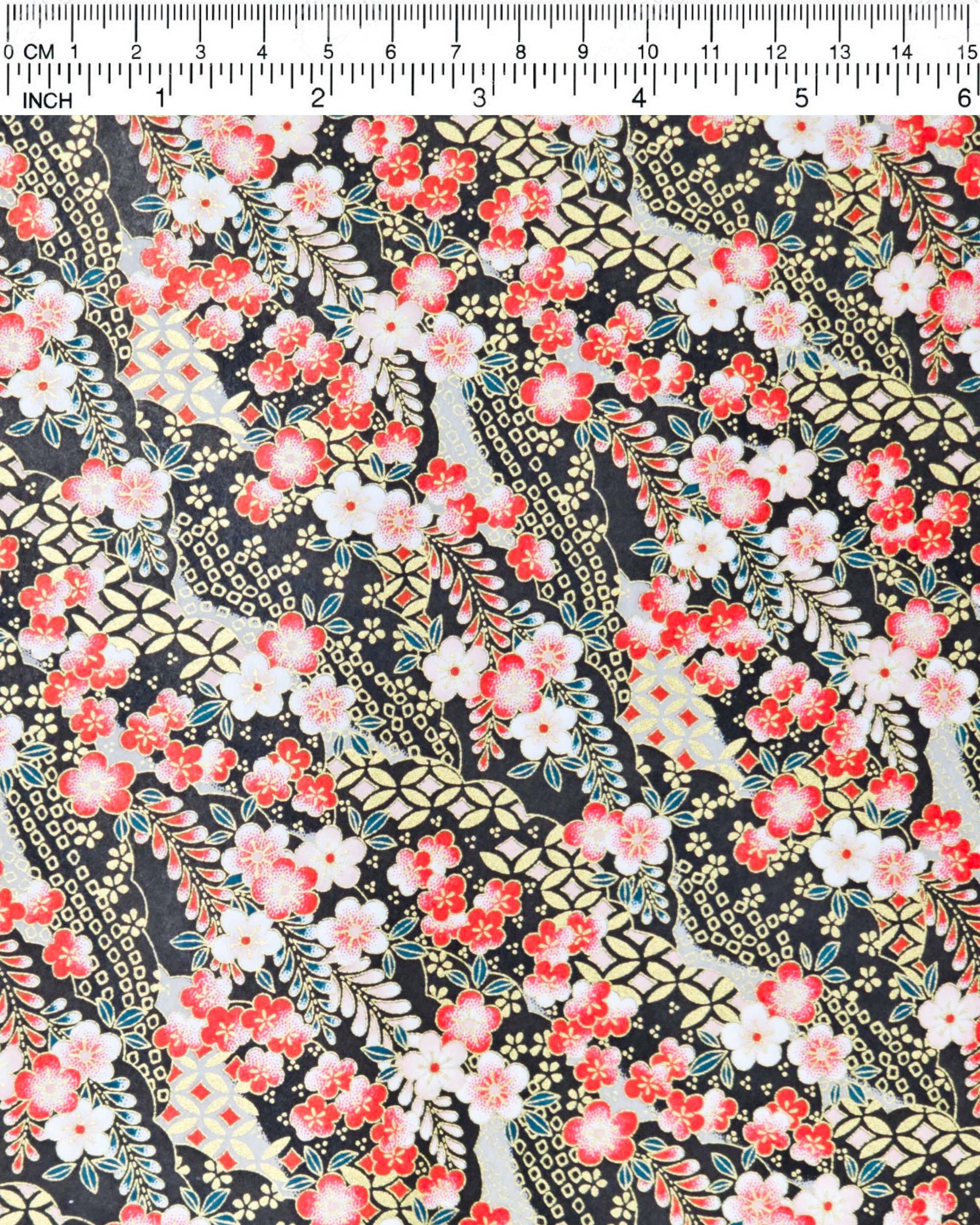 Japanese chiyogami paper featuring red and white plum blossoms with red, white, and green wisteria on a black back ground with metallic gold accents.