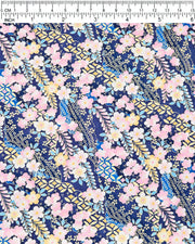 Japanese chiyogami paper featuring pink and yellow plum blossoms and blue, pink, and yellow wisteria on a dark blue background with metallic gold details, shown next to a ruler for size reference.