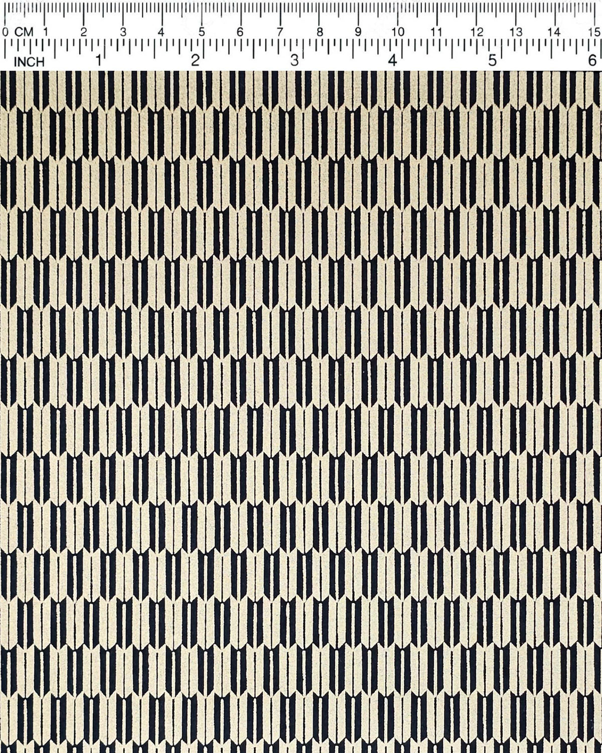 Japanese chiyogami paper featuring a traditional black and metallic gold yagasuri (arrow feather) pattern, shown next to a ruler for size reference.