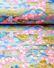 Japanese chiyogami paper featuring a blue and pink cherry blossom-filled Japanese village with metallic gold accents.