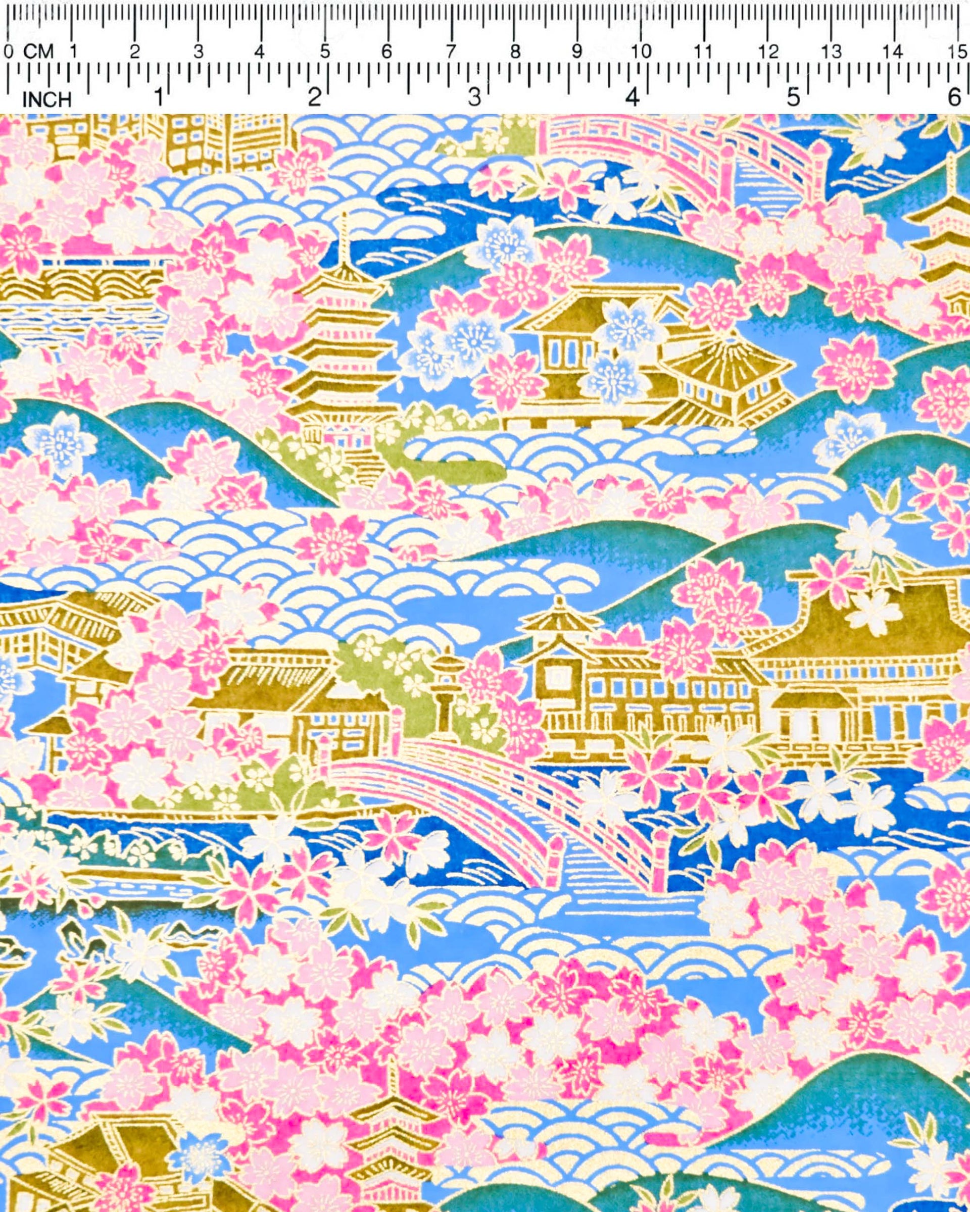 Japanese chiyogami paper featuring a blue and pink cherry blossom-filled Japanese village with metallic gold accents.