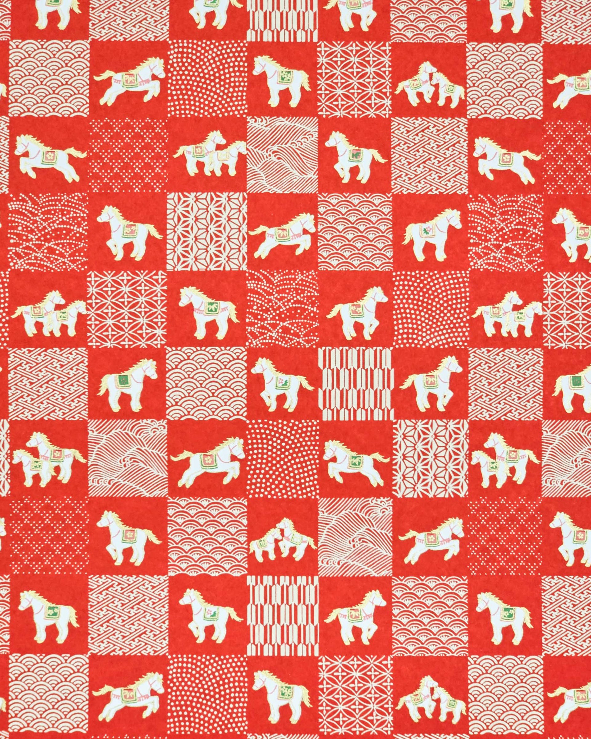 Japanese chiyogami paper featuring white horses with red and green accents and white assorted traditional Japanese designs in an ichimatsu (checker) design on a red background with metallic gold accents.