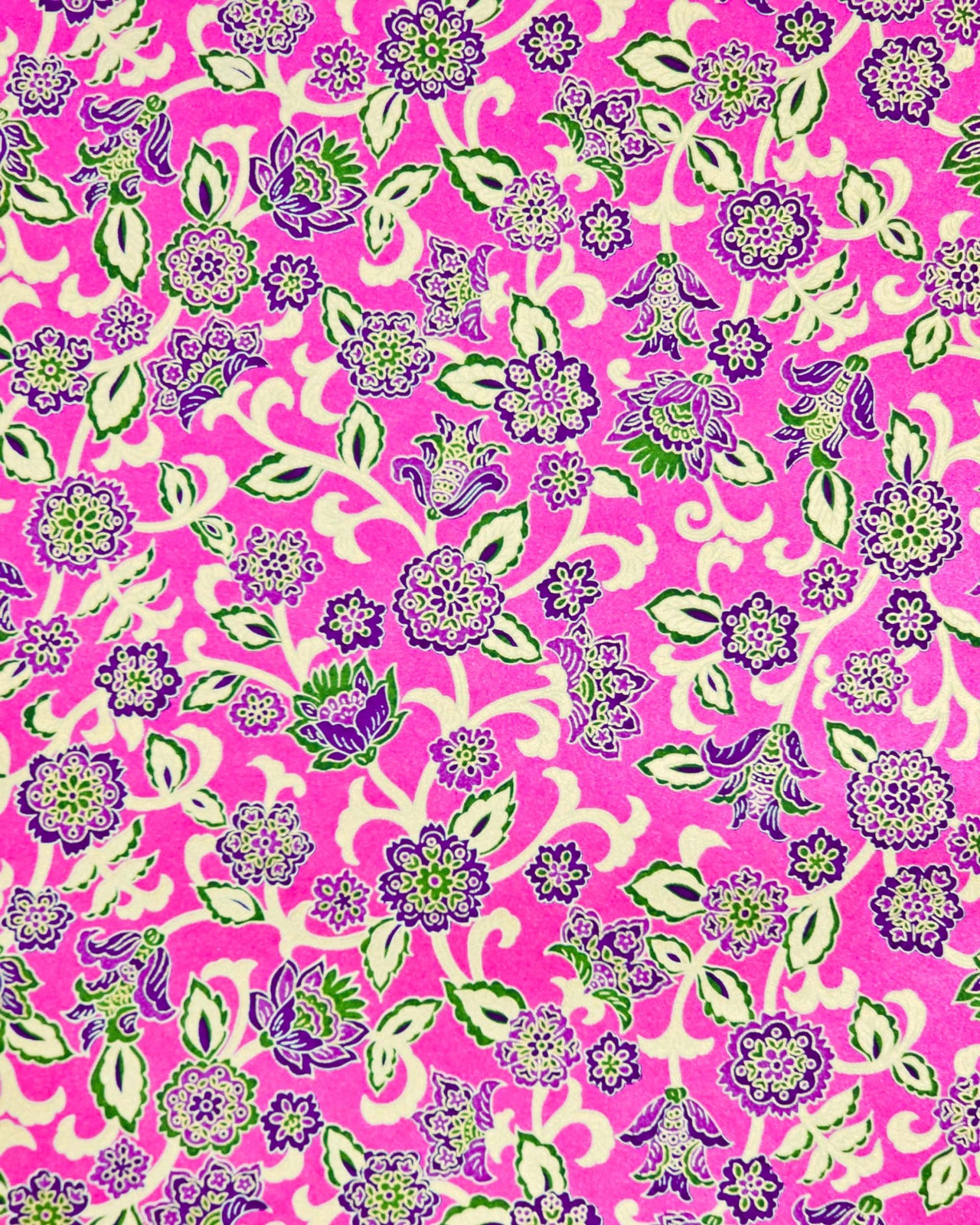 Japanese chiyogami paper featuring green and purple sarasa flowers on a pearlescent magenta pink background with metallic gold accents.