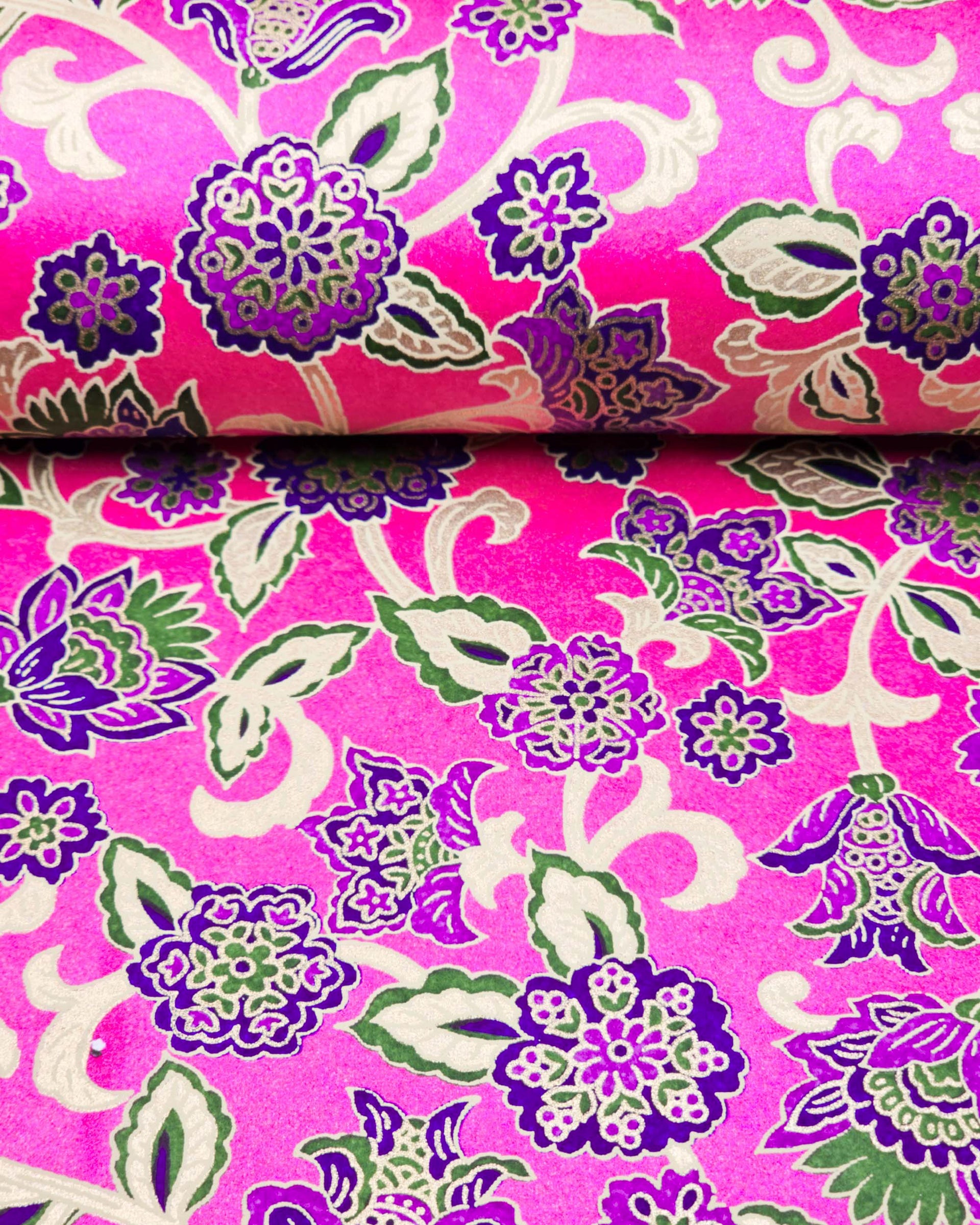 Japanese chiyogami paper featuring green and purple sarasa flowers on a pearlescent magenta pink background with metallic gold accents.