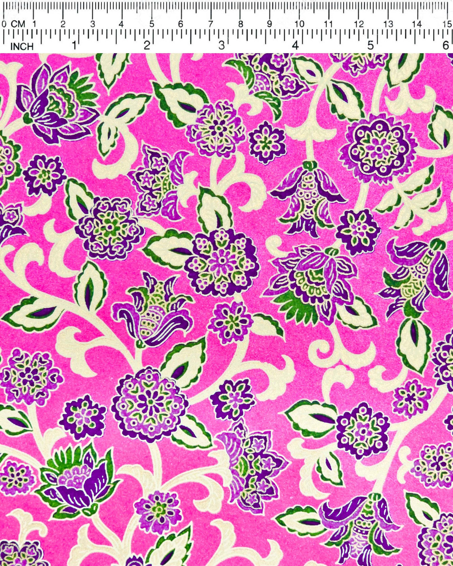 Japanese chiyogami paper featuring green and purple sarasa flowers on a pearlescent magenta pink background with metallic gold accents.