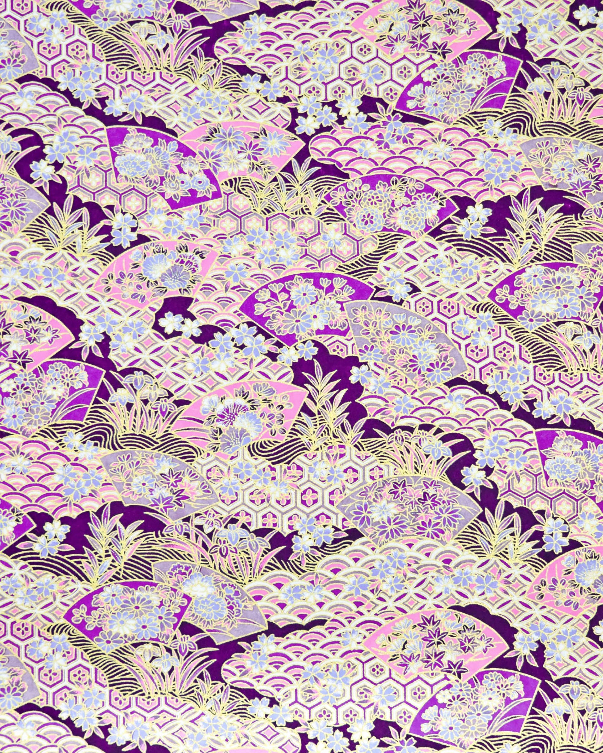 Japanese chiyogami paper featuring purple and pink floral hand fans and various traditional Japanese geometric motifs (shippo, kikko, seigaiha) on a dark purple background with metallic gold accents. Small purple and white cherry blossom are scattered throughout the design.