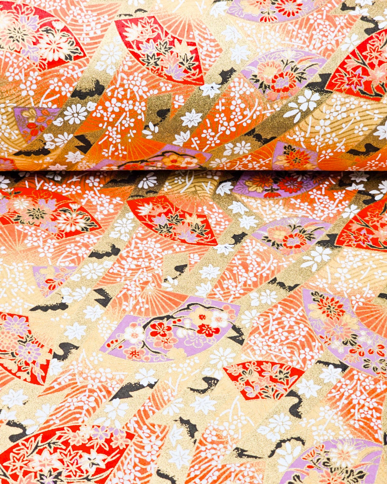 Japanese chiyogami paper featuring red and purple floral hand fans and gold floral ribbons on an orange gradient background covered in small white plum blossoms with metallic gold details.