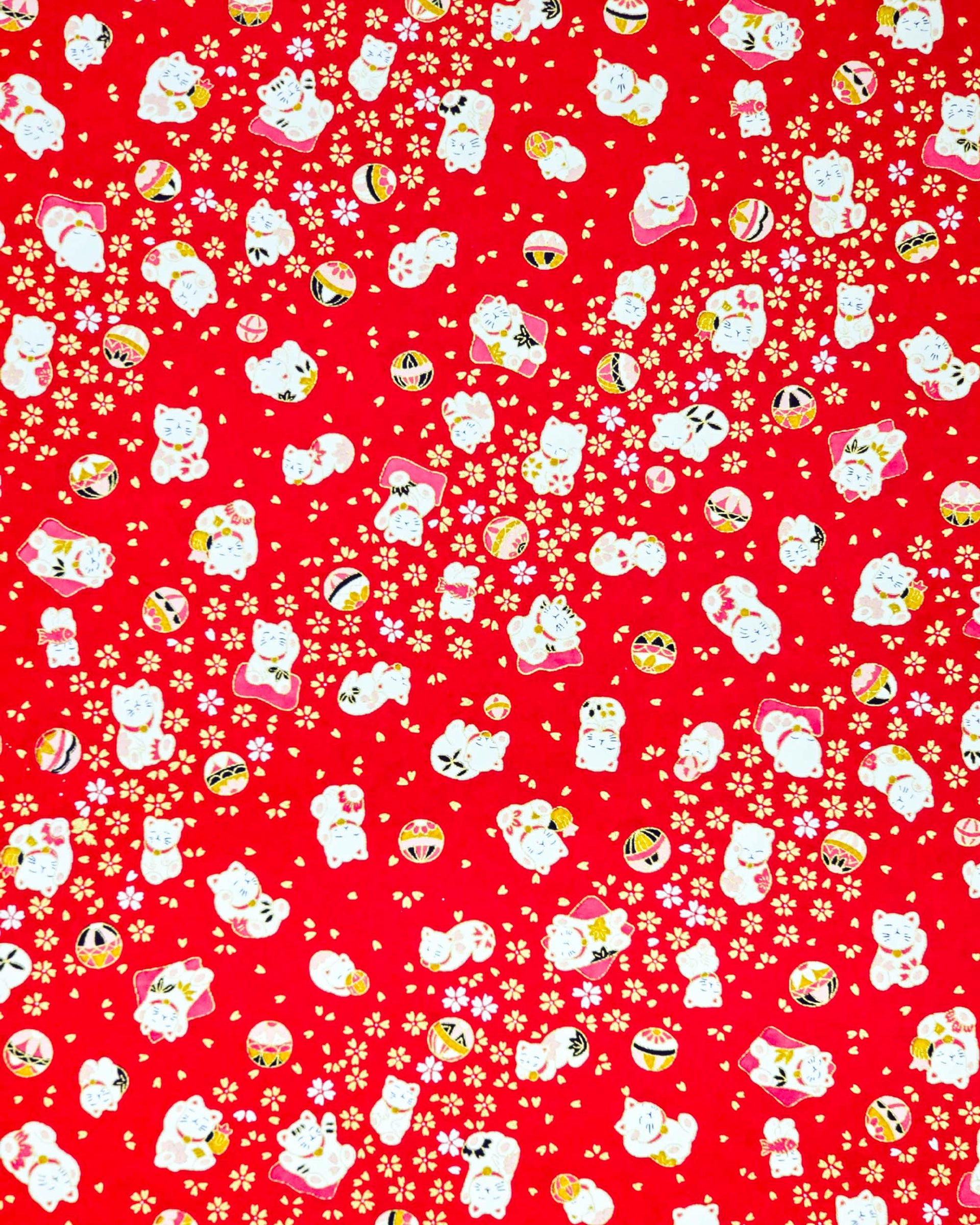 Japanese chiyogami paper featuring assorted white and red Maneki Neko (lucky cats) with small white and gold cherry blossoms and temari balls on a bright red background with metallic gold details.