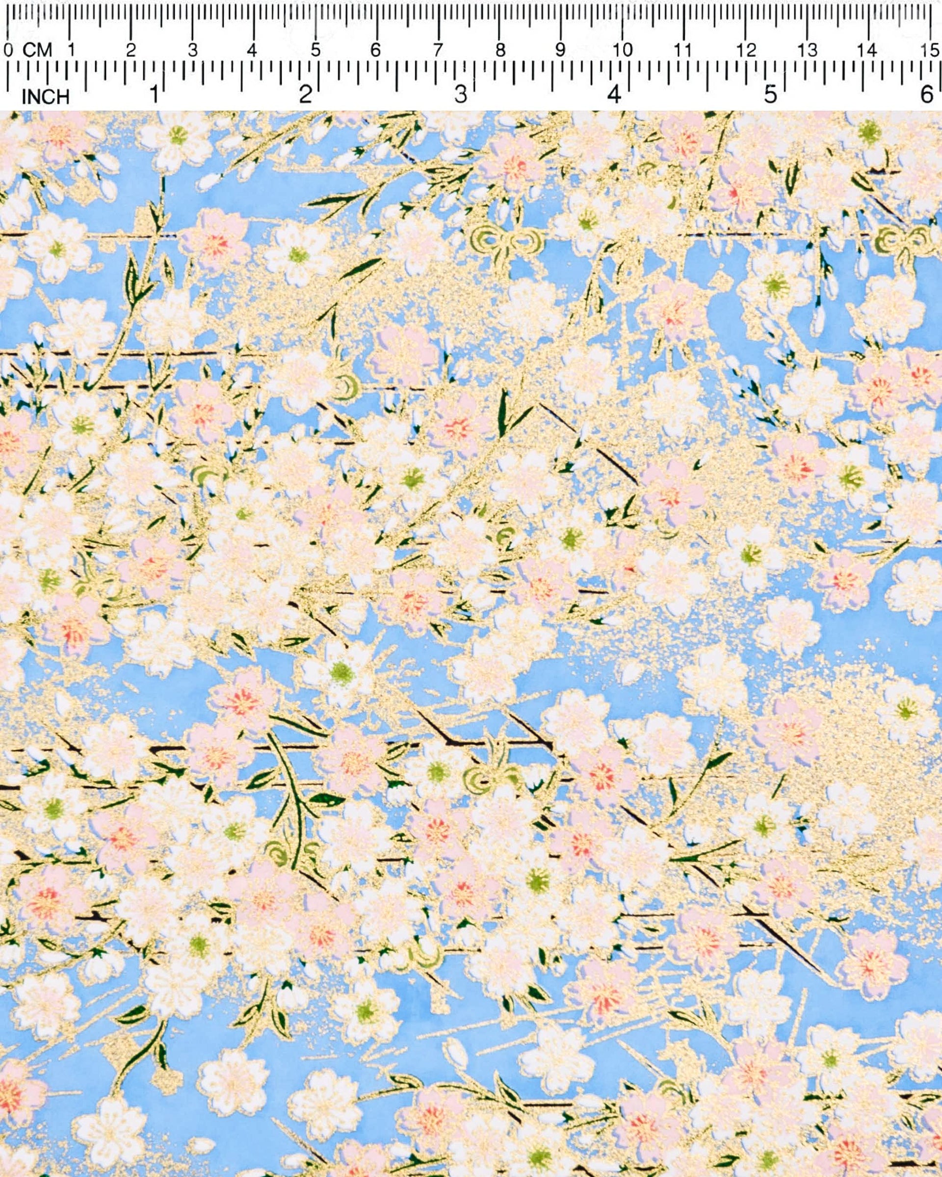 Japanese chiyogami paper featuring light pink and white cherry blossoms on a sky blue background with metallic gold details.