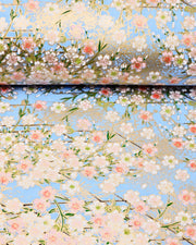 Japanese chiyogami paper featuring light pink and white cherry blossoms on a sky blue background with metallic gold details.
