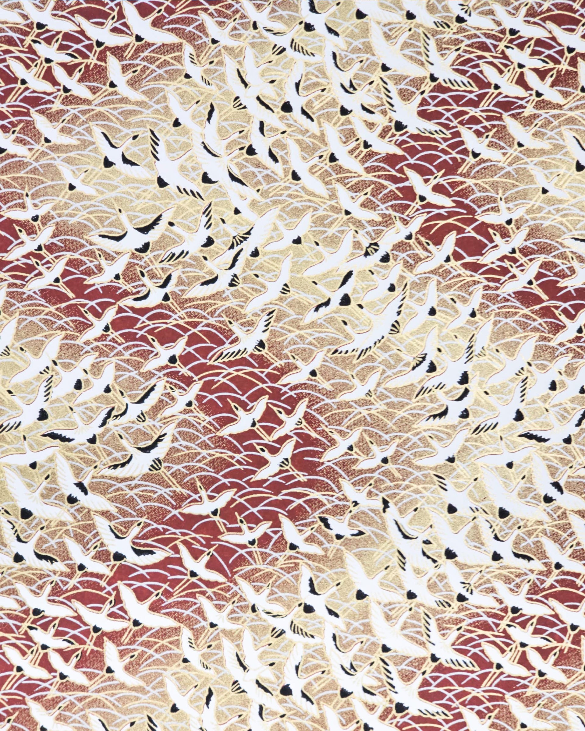 Japanese chiyogami paper featuring white flying cranes in a zigzag formation on a brown background with metallic gold and silver details.