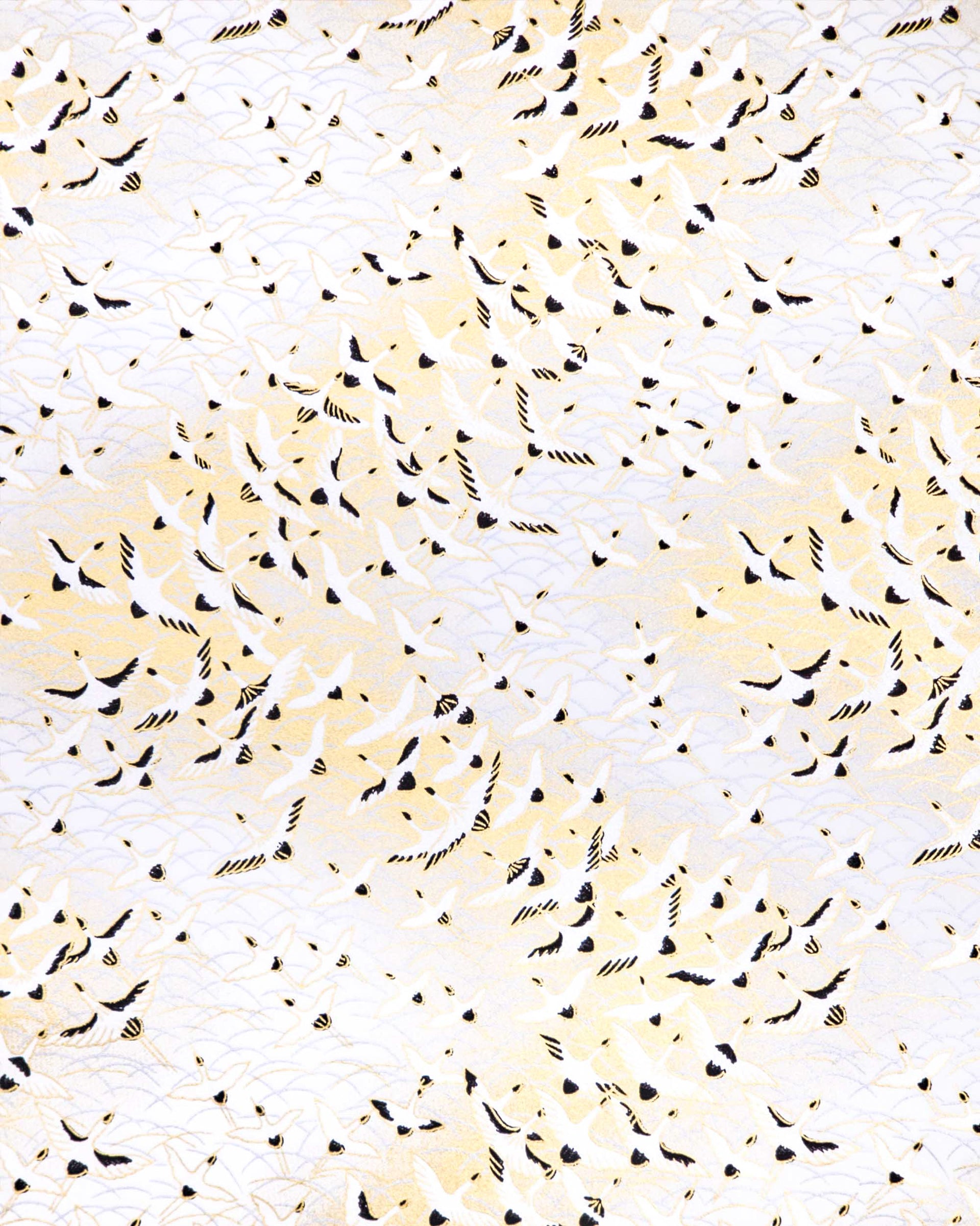 Japanese chiyogami paper featuring pearlescent white flying cranes in a zigzag formation on a white background with metallic gold and silver details.