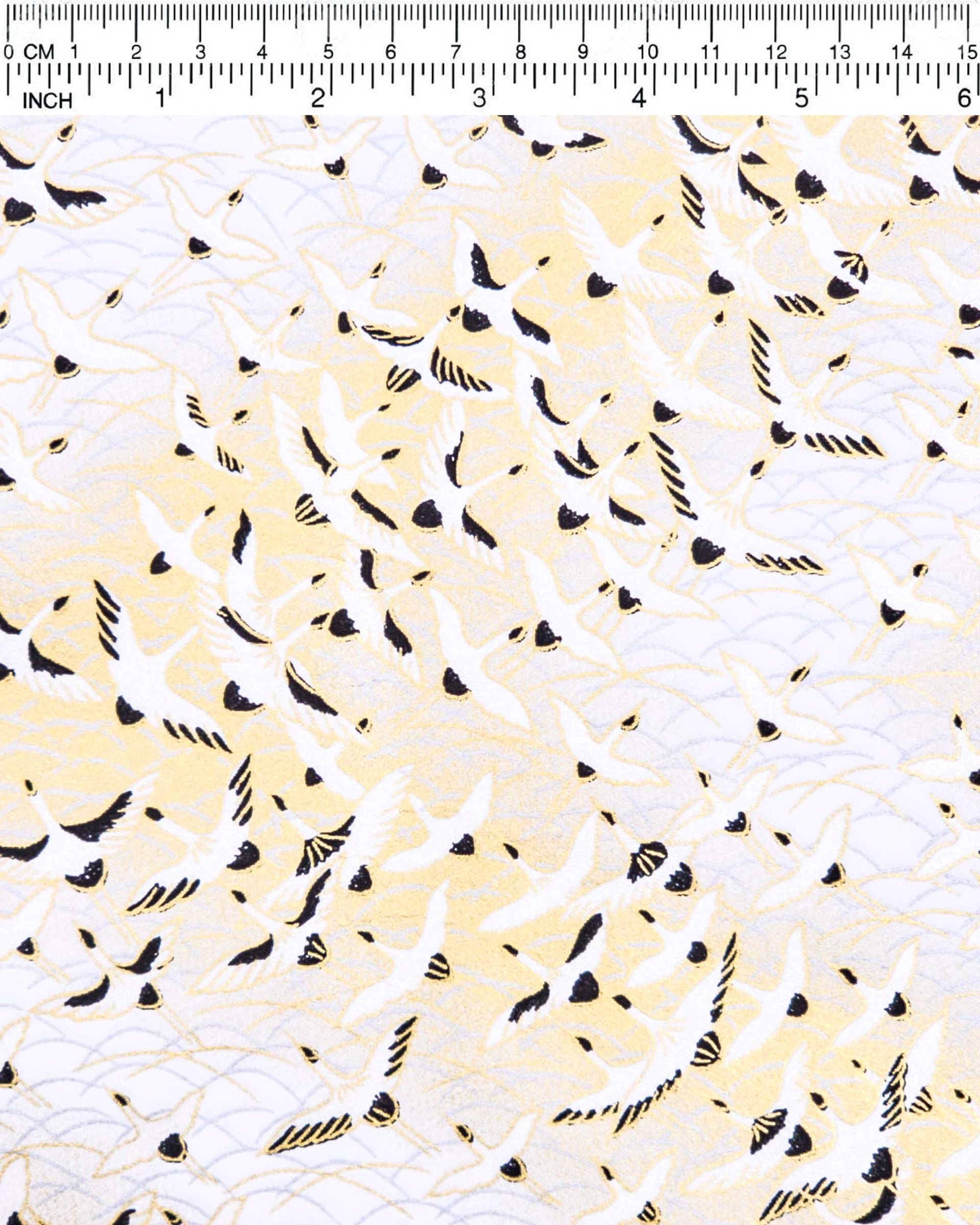 Japanese chiyogami paper featuring pearlescent white flying cranes in a zigzag formation on a white background with metallic gold and silver details.