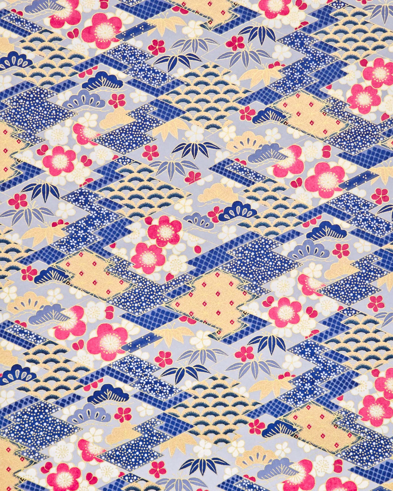 Japanese chiyogami paper featuring large pearlescent magenta pink and white plum blossoms, blue and gold bamboo leaves, and light blue and gold pine on a blue and gold background with metallic gold accents. The background is adorned with a various traditional Japanese geometric designs.