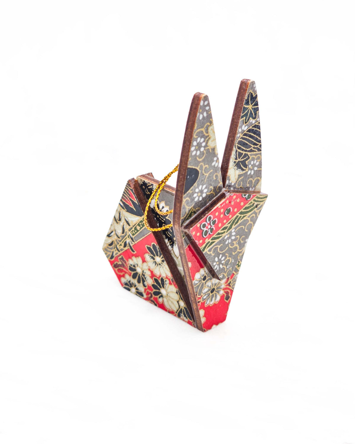 Small wooden origami rabbit ornament featuring red, gray, black, and off white patches with an assortment of various floral patterns and metallic gold details.
