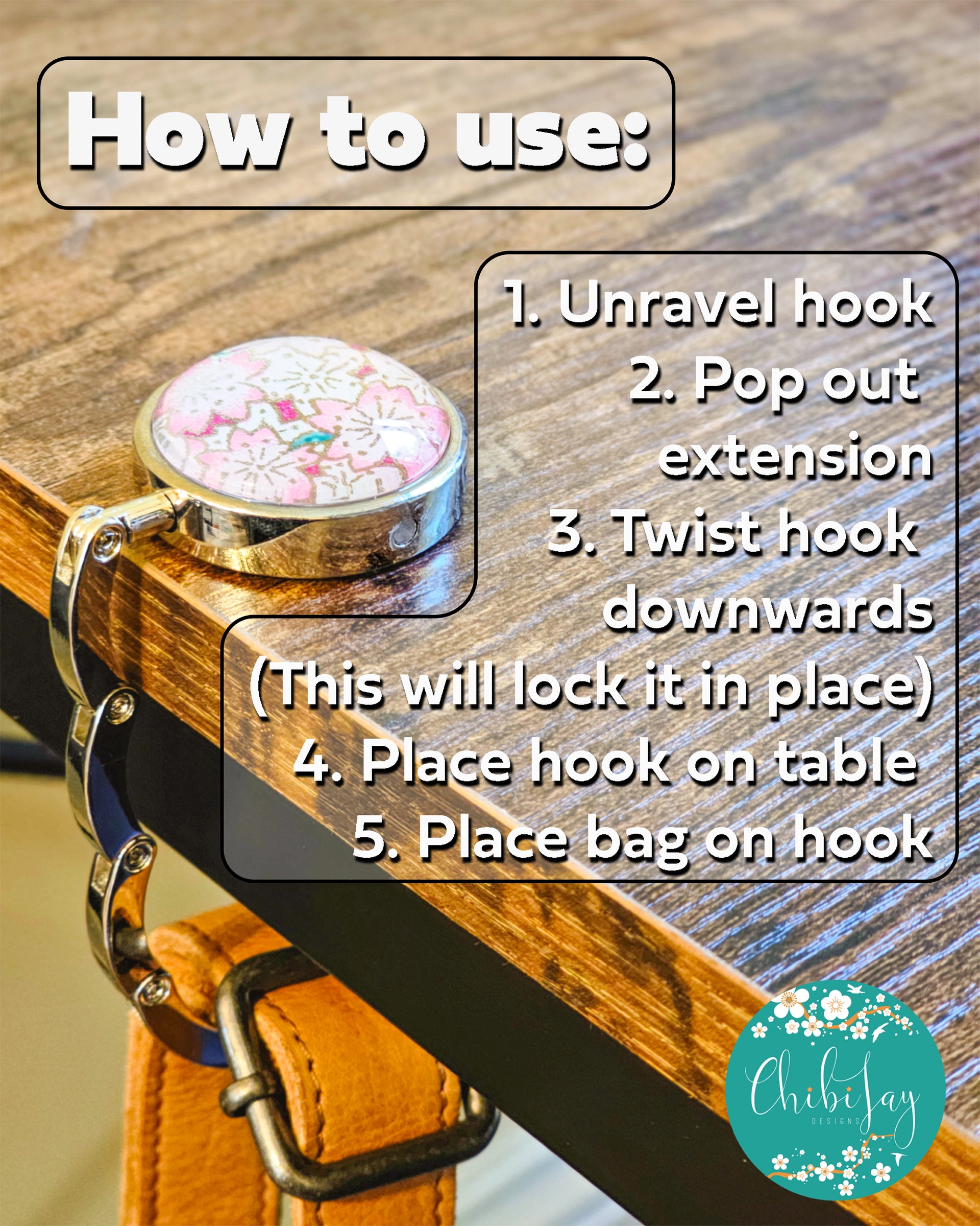 Table-top bag hanger with pink cherry-blossom top hanging from a table, holding a bag, with usage instructions on the image.