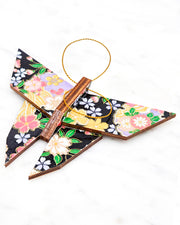 Large wooden origami butterfly ornament featuring pink, yellow, purple, and white cherry blossoms and purple yukiwa on a black background with metallic gold details.