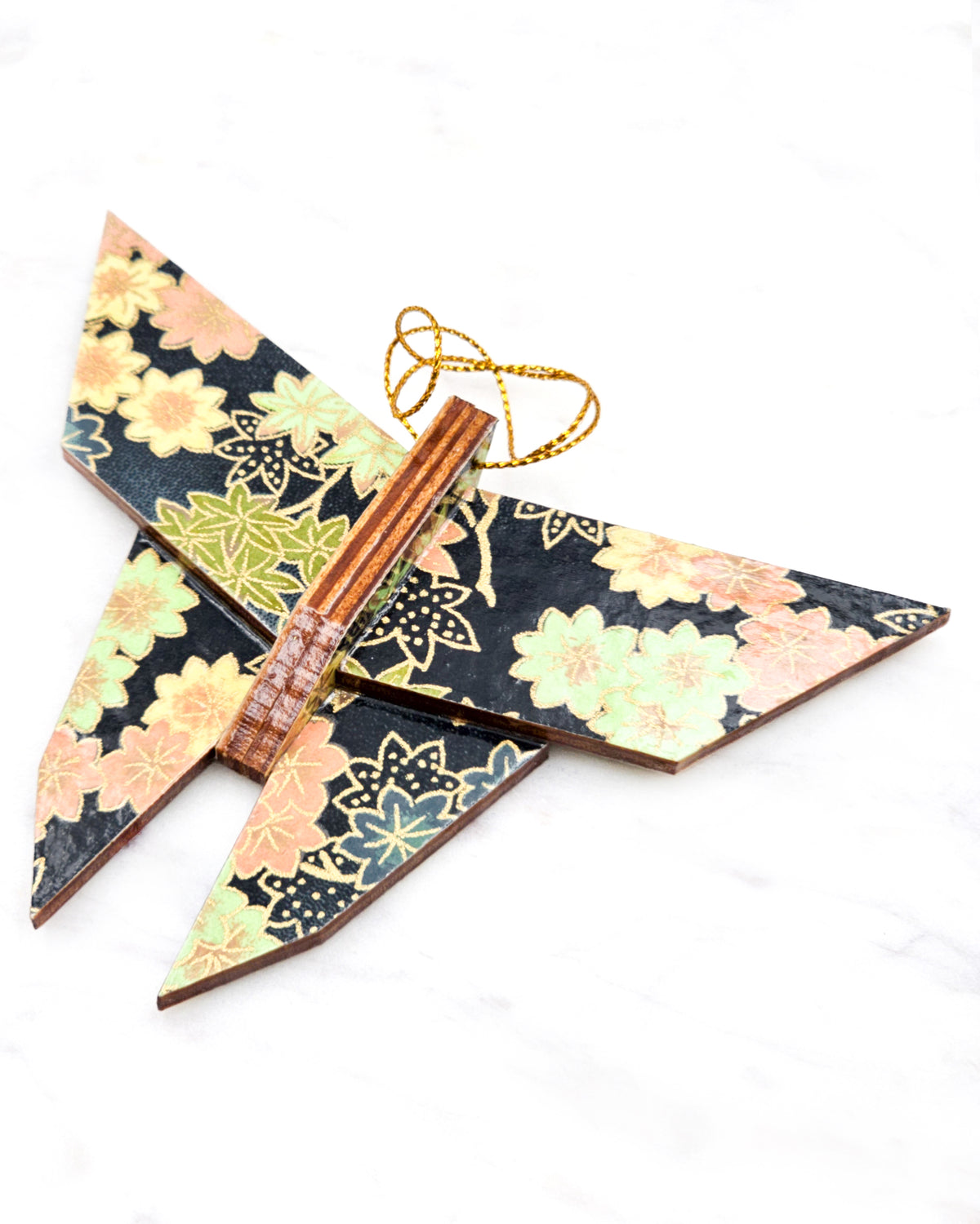 Large wooden origami butterfly ornament featuring assorted green, pink, beige, and gray maple leaves with dark gray and metallic gold dotted maple leaves on a dark gray background.