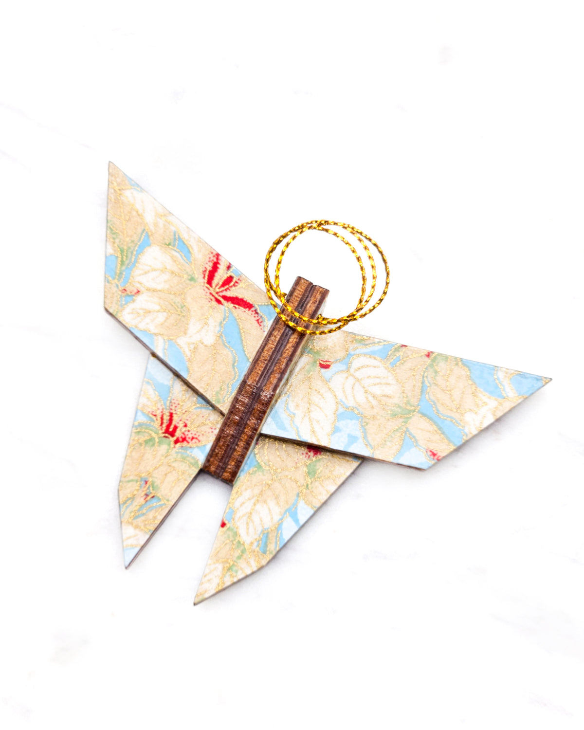 Small wooden origami butterfly ornament featuring beige and white leaves on a light blue background with metallic gold details.