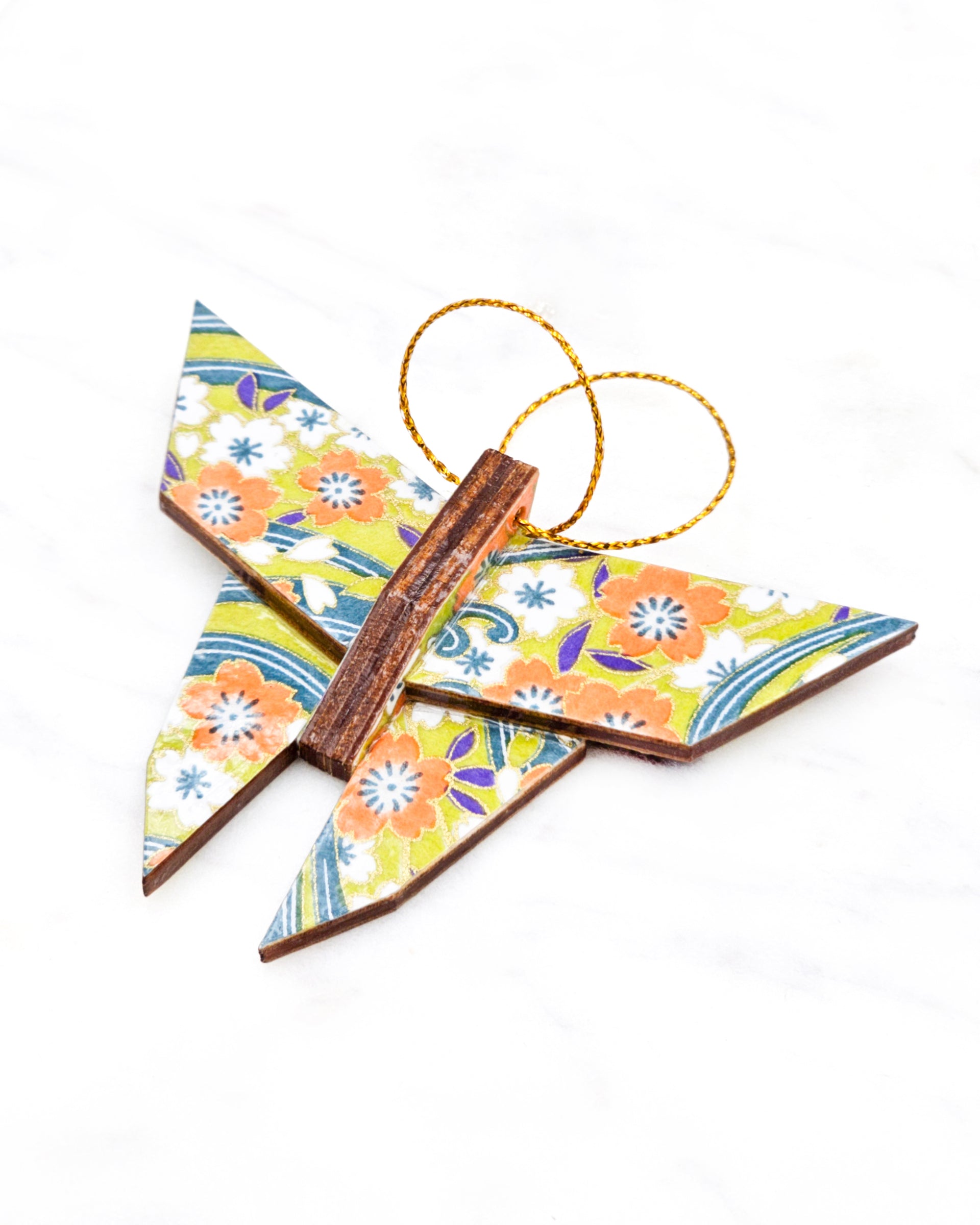 Small wooden origami butterfly ornament featuring orange and white plum blossoms with on a green and blue background with metallic gold details.