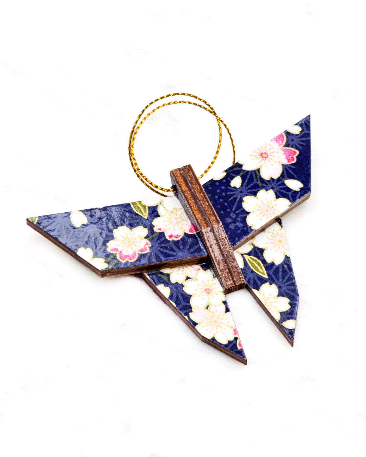 Small wooden origami butterfly ornament featuring pink and white cherry blossoms on a dark blue background with metallic gold details.