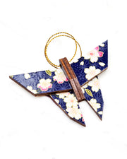 Small wooden origami butterfly ornament featuring pink and white cherry blossoms on a dark blue background with metallic gold details.