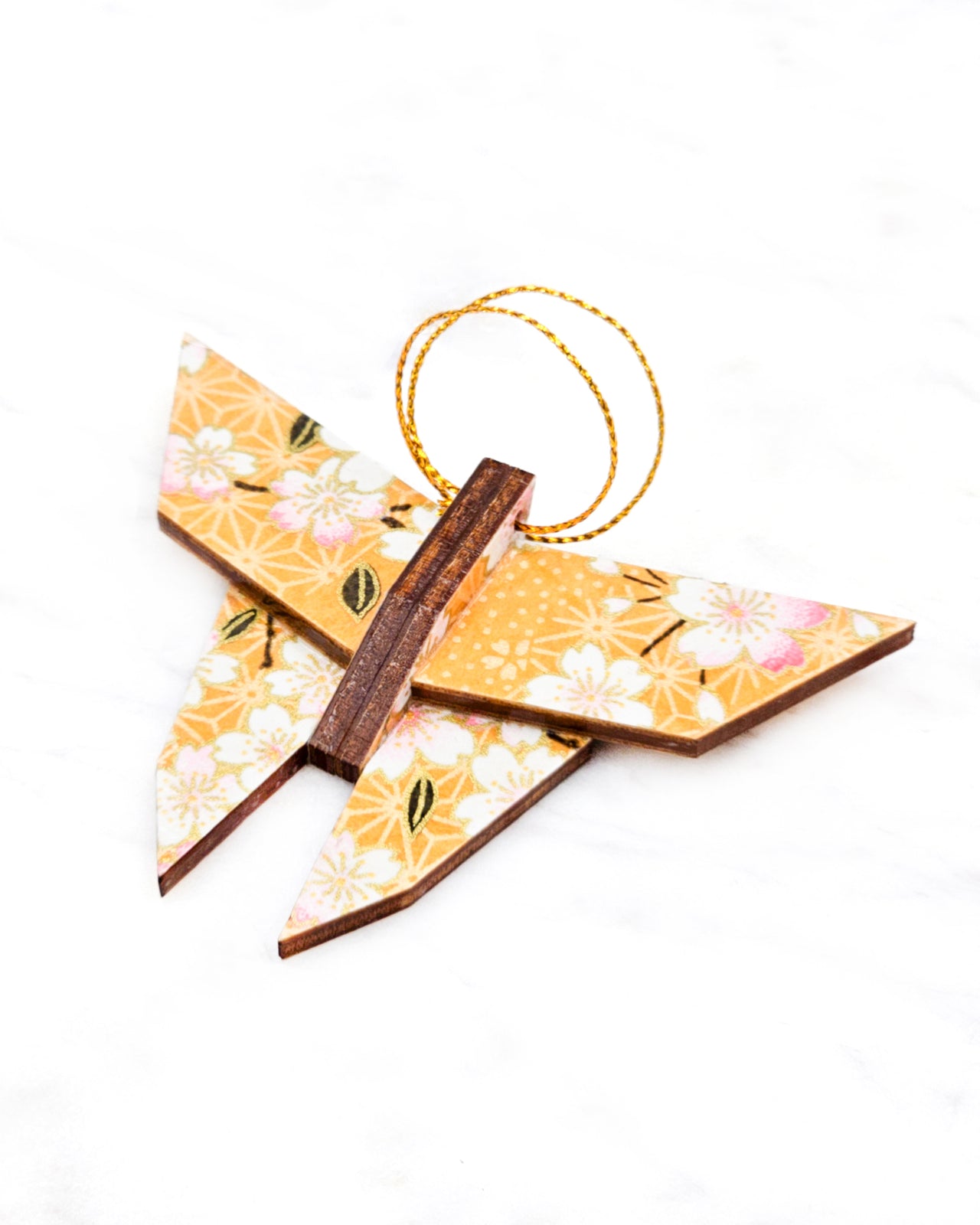 Small wooden origami butterfly ornament featuring pink and white cherry blossoms on an orange background with metallic gold details.