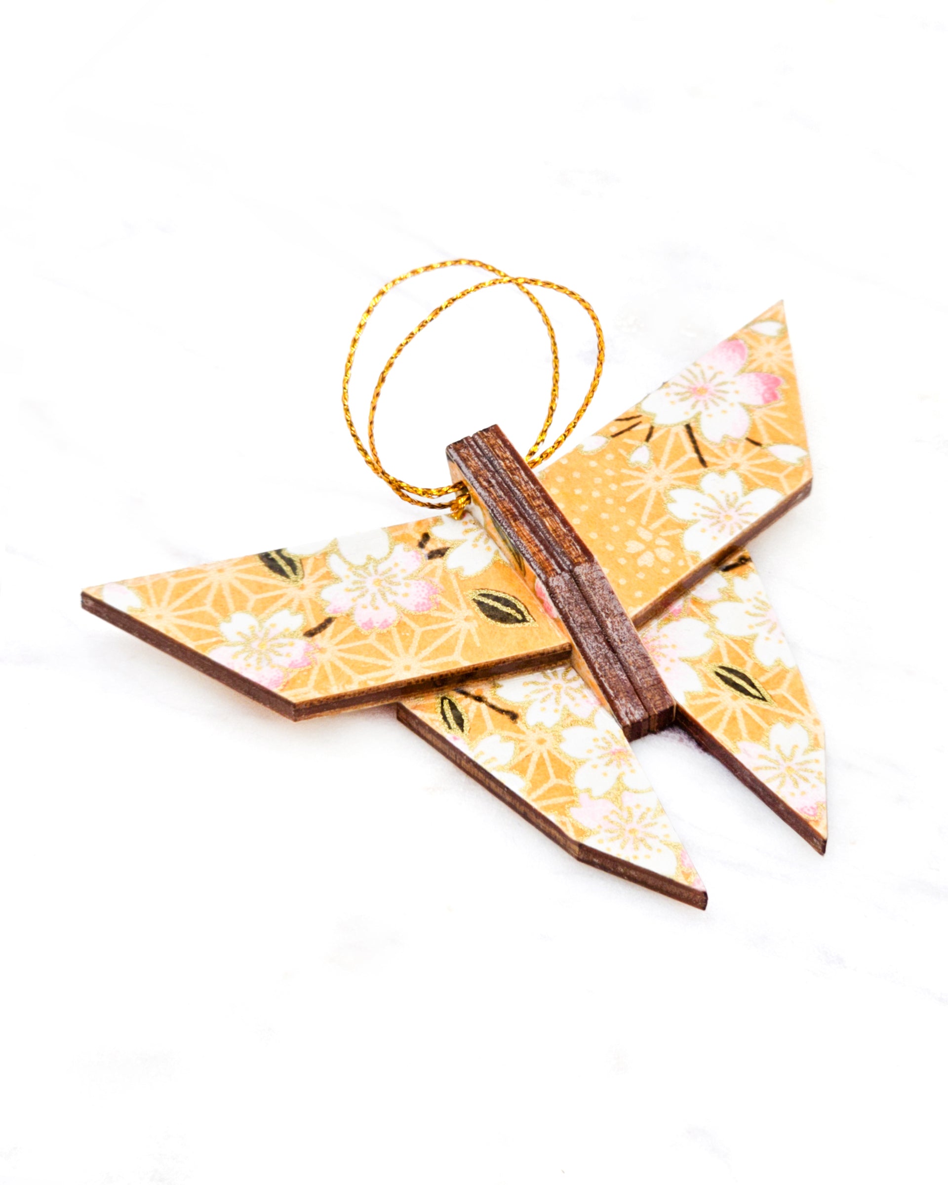 Small wooden origami butterfly ornament featuring pink and white cherry blossoms on an orange background with metallic gold details.