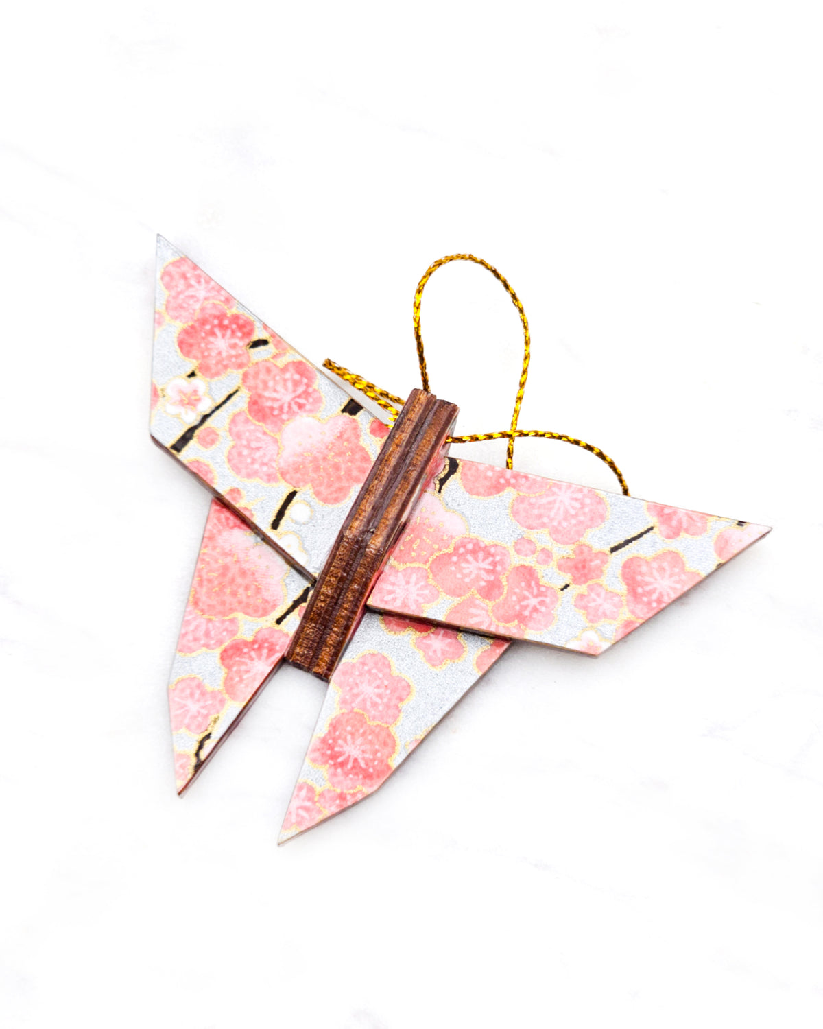 Small wooden origami butterfly ornament featuring pink and white plum blossoms with dark brown branches on a silver background with metallic gold details.