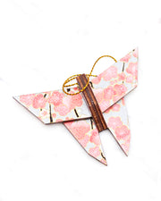Small wooden origami butterfly ornament featuring pink and white plum blossoms with dark brown branches on a silver background with metallic gold details.