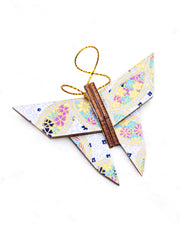 Small wooden origami butterfly ornament featuring a blue, yellow, and purple shippo design filled with assorted floral and geometric designs on a light purple background with metallic gold details.