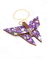 Small wooden origami butterfly ornament featuring purple and white plum blossoms with dark brown branches on a green background with metallic gold details.
